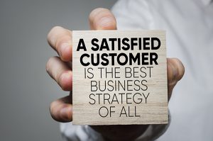 NJ ITM Service, Businessman holding block with statement about satisfied customers, NJ ITM service equals happier clients