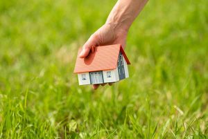 Custom home builder in New Jersey, Toy home shown being placed in a field of green grass